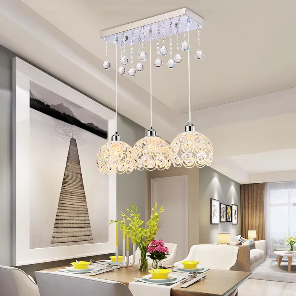 This light luxury three-head dining chandelier features a black metal top frame, paired with silver suspension rods and hollow black-gold spherical lampshades (embedded with crystal accents), with an exquisite and brilliant shape, serving both lighting and decorative purposes, ideal for dining rooms, bars, light luxury homes and other scenarios.
