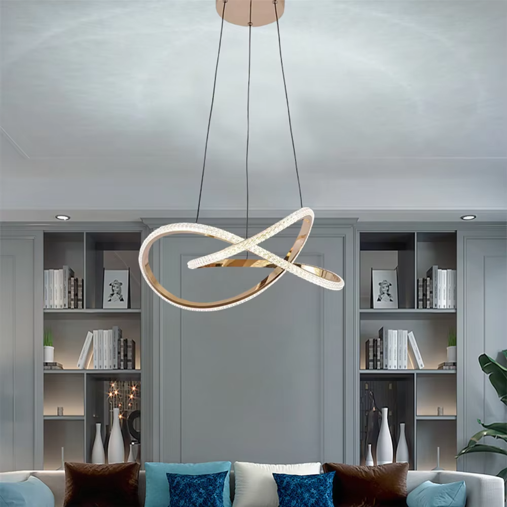 This is a modern artistic golden crossed ring chandelier, with a golden metal crossed ring structure and embedded crystal elements, featuring a minimalist and grand design, brilliant lighting. It is used for space lighting and decoration, creating a modern luxurious atmosphere. Suitable for modern minimalist living rooms, high-end creative restaurants, designer studios and other places.