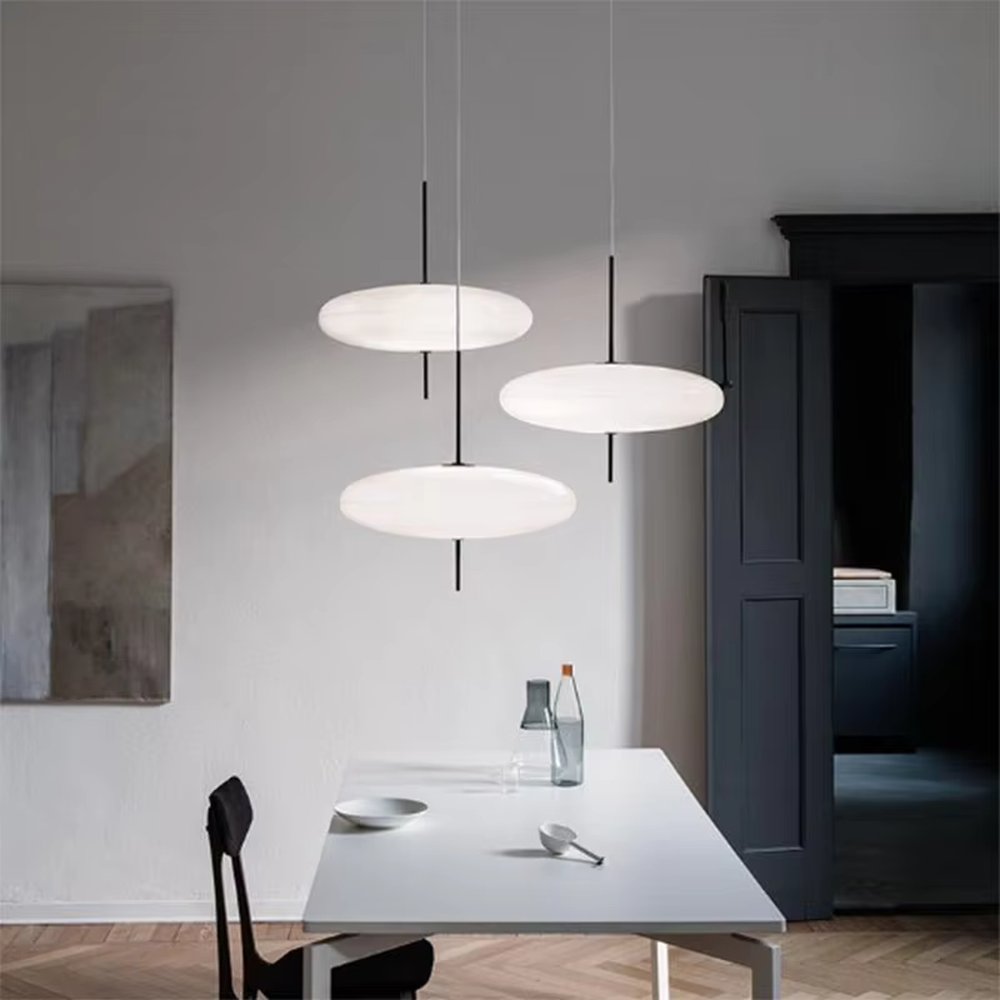 This modern minimalist flat round chandelier features a milky white frosted acrylic lampshade, paired with a thin black suspension rod, transmitting light softly. It serves both lighting and decorative purposes, ideal for modern minimalist spaces such as living rooms, bedrooms, and light luxury restaurants.