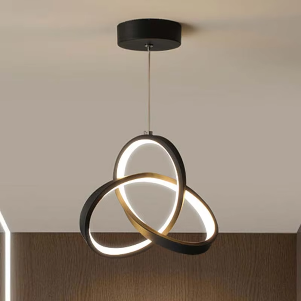 Modern minimalist black-gold interwoven triple-ring LED pendant light, warm light effect, creating a minimalist artistic space atmosphere.
