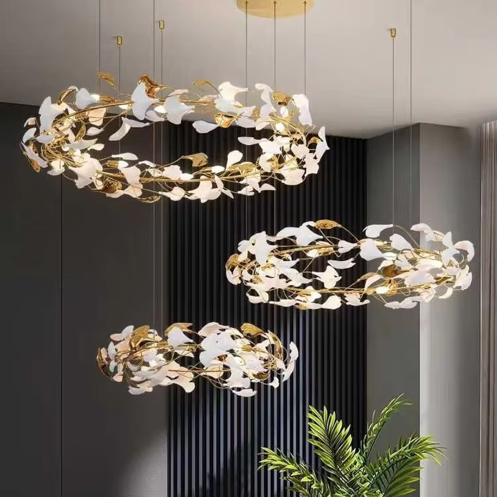 This is a new Chinese luxury ginkgo leaf multi-layer chandelier, with a golden metal frame and white ginkgo leaf design, featuring natural art and luxury texture. It is used for space lighting and decoration, creating a natural luxury ambiance. It is suitable for high-end residential double-height living rooms, luxury hotel lobbies, art clubs and other places.