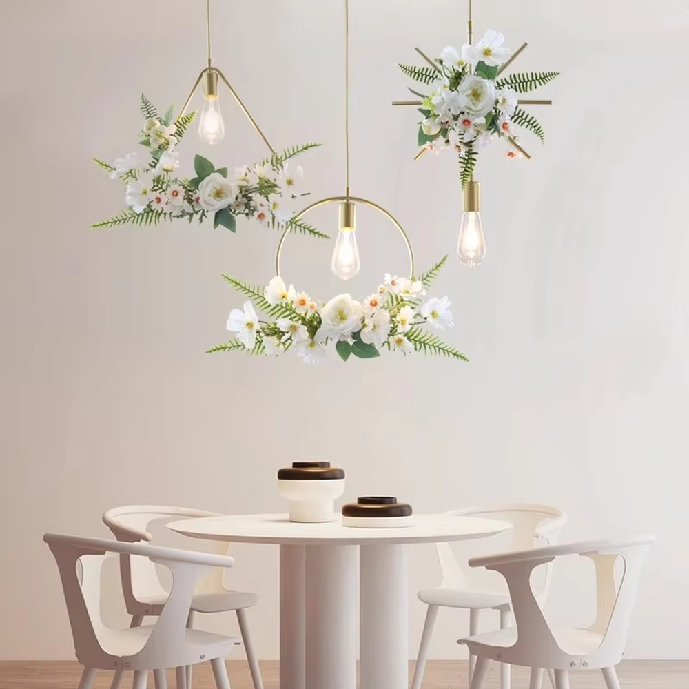 This is a romantic fresh-style geometric frame floral combination small chandelier, including golden metal star/triangle/circle frames, paired with pink-white artificial flowers and green plant decorations, and retro bulbs. The lighting is warm and soft, creating a romantic fresh atmosphere.