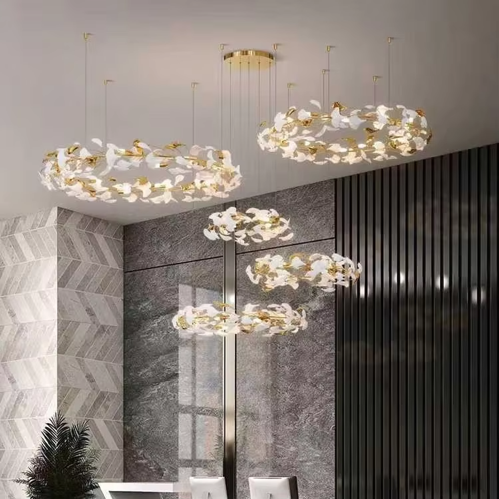 This is a new Chinese luxury ginkgo leaf multi-layer chandelier, with a golden metal frame and white ginkgo leaf design, featuring natural art and luxury texture. It is used for space lighting and decoration, creating a natural luxury ambiance. It is suitable for high-end residential double-height living rooms, luxury hotel lobbies, art clubs and other places.