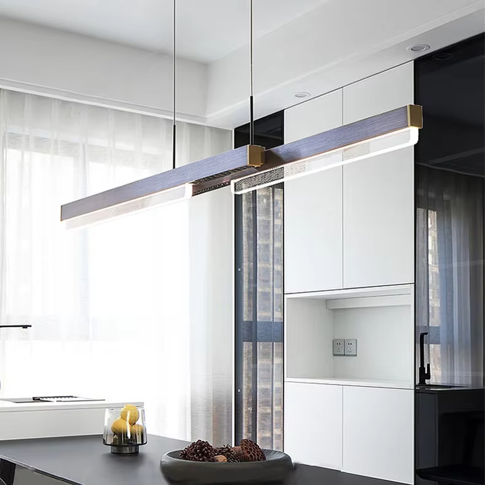 This is a modern minimalist style linear chandelier, featuring a walnut texture panel paired with brass metal accents. The linear lighting design emits soft and uniform light, serving both practical lighting and space decoration purposes, suitable for dining rooms, open kitchens, light luxury bars, modern office areas and other scenarios.