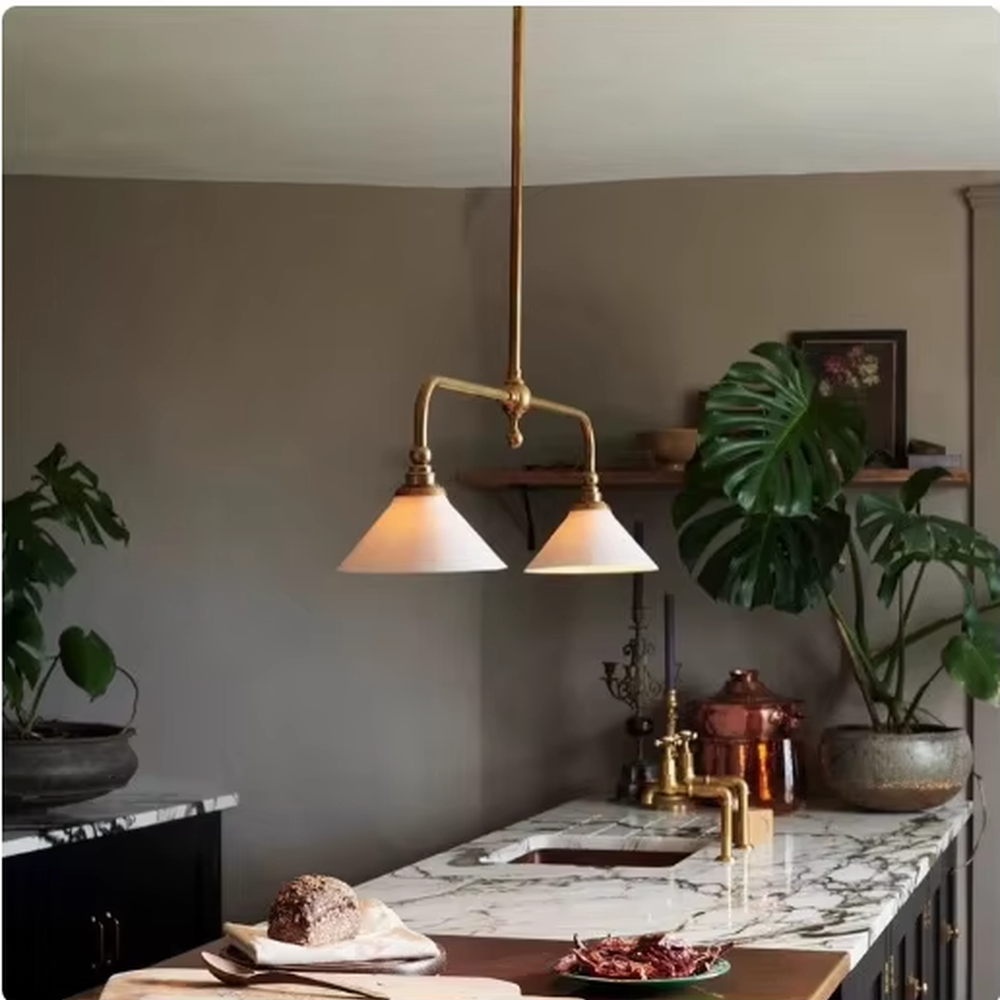 This is a Nordic retro-style double-head chandelier, with a golden metal stand and white conical lampshades, featuring a minimalist retro design and warm texture. It is used for space lighting and decoration, creating a warm retro atmosphere. It is suitable for Nordic-style restaurants, retro-style home living rooms, homestay dining areas and other places.