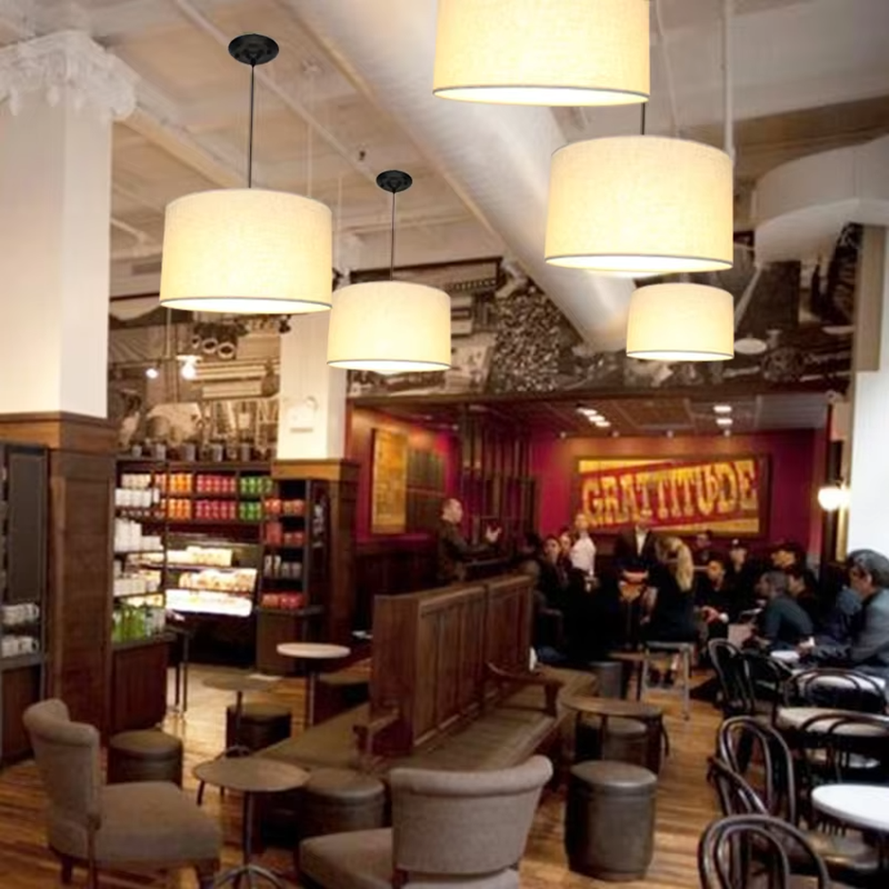 Minimalist beige fabric cylindrical hanging chandelier, metal suspension rod + fabric lampshade, soft and uniform lighting, creating a warm and leisure atmosphere.