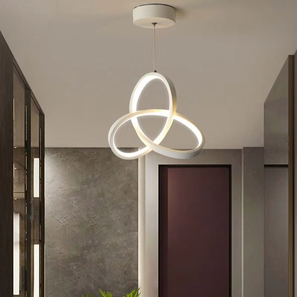 Modern minimalist black-gold interwoven triple-ring LED pendant light, warm light effect, creating a minimalist artistic space atmosphere.