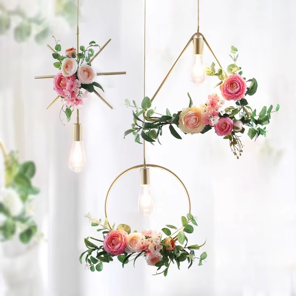 This is a natural and fresh floral metal chandelier, including two styles of golden circular and radial metal frames, paired with artificial green plants, flowers and transparent bulbs. It features a natural and romantic design with warm and soft lighting. It is used for space lighting and decoration, creating a natural and romantic atmosphere. Suitable for Nordic-style homes, literary cafes, wedding venues, art homestays and other places.