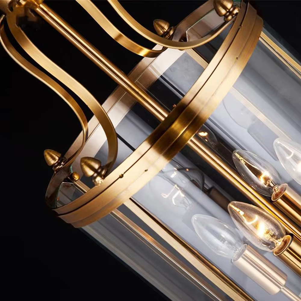 Light luxury golden metal cage-style cylindrical glass cover candelabra chandelier, golden frame + transparent cylindrical glass cover + candle-shaped bulbs, soft warm light, suitable for modern minimalist dining area atmosphere.