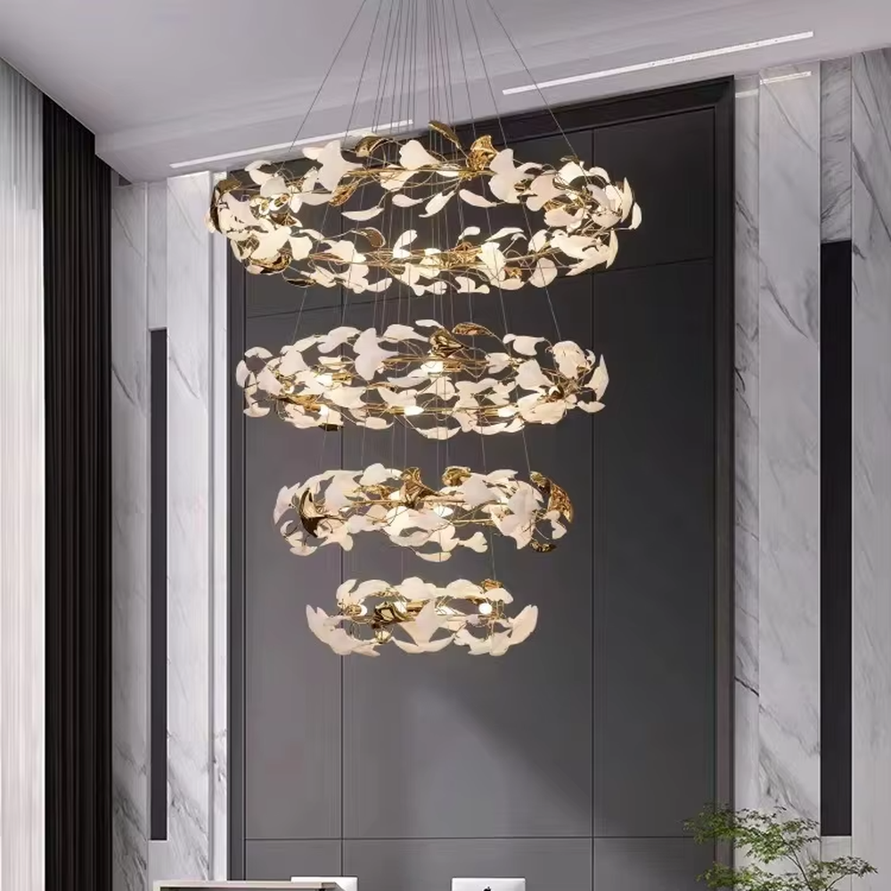 This is a new Chinese luxury ginkgo leaf multi-layer chandelier, with a golden metal frame and white ginkgo leaf design, featuring natural art and luxury texture. It is used for space lighting and decoration, creating a natural luxury ambiance. It is suitable for high-end residential double-height living rooms, luxury hotel lobbies, art clubs and other places.