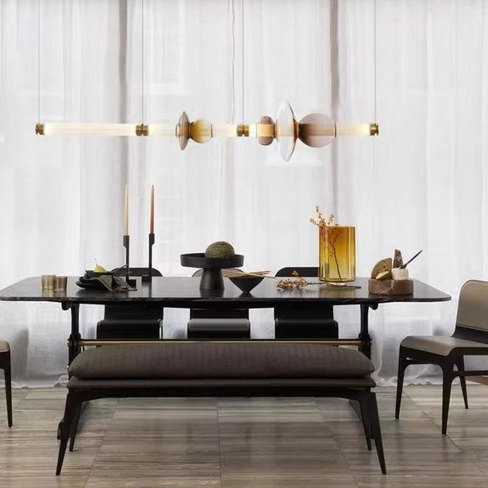 Modern artistic hanging combination chandelier, gradient glass components + copper metal decorations + milky white long tubes, soft lighting, creating an artistic minimalist atmosphere.