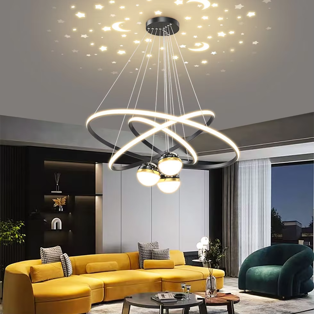This is a modern creative cross-ring starry sky projection chandelier, with a black frame paired with cross-ring light strips and spherical lamps, and a starry sky (star and moon) projection function. The design is modern and dreamy, with soft lighting and a strong atmosphere. It is used for space lighting and atmosphere creation, suitable for modern-style living rooms, children's rooms, light luxury-style bedrooms and other places.
