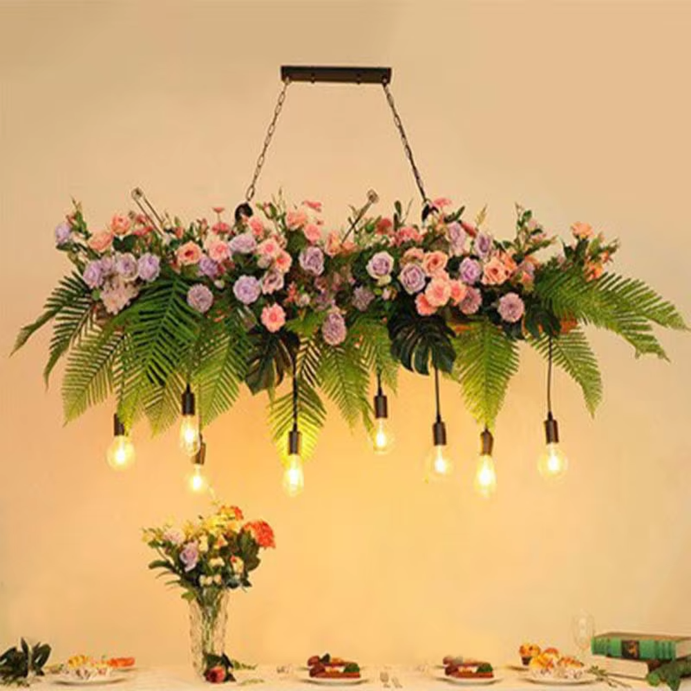 This is a romantic natural-style long strip floral retro chandelier, with blue and white artificial flowers (hydrangeas, orchids, etc.) and green plants as the main decoration, paired with retro bulbs. It has a fresh and romantic style, with warm and soft lighting.
