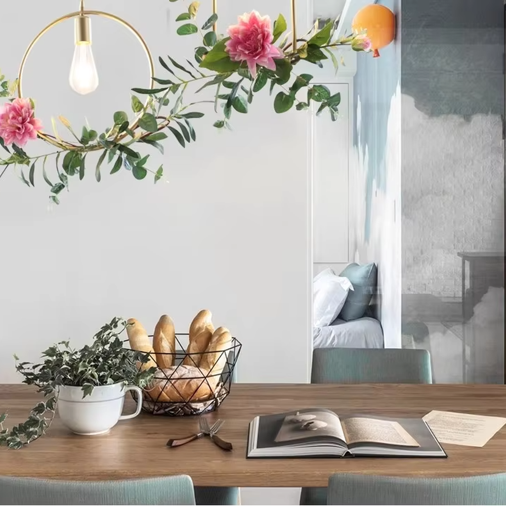 This is a romantic fresh-style geometric frame floral combination small chandelier, including golden metal star/triangle/circle frames, paired with pink-white artificial flowers and green plant decorations, and retro bulbs. The lighting is warm and soft, creating a romantic fresh atmosphere.