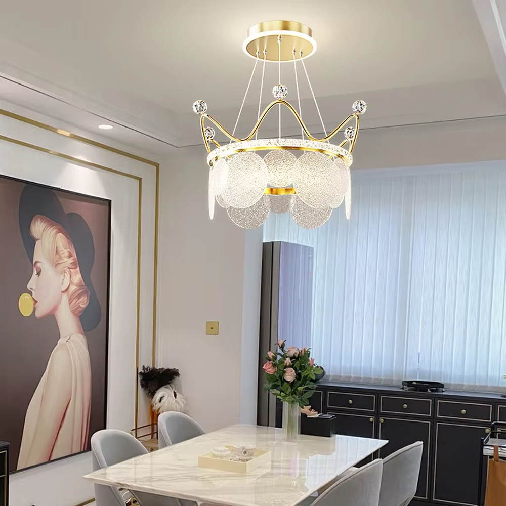 A light luxury princess-style crown-shaped chandelier, featuring a gold metal crown frame paired with crystal decorations and glowing glass lampshades. It emits a brilliant yet soft glow when lit, combining decorative appeal with practical illumination, ideal for creating a romantic and dreamy space atmosphere.