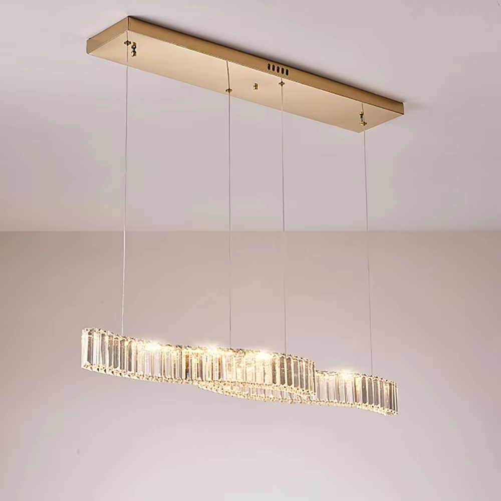 This modern light luxury linear chandelier features a gold metal ceiling plate, paired with faceted crystal strips to create an irregular undulating shape. Light refracts through the crystals to emit a brilliant glow, serving both lighting and decorative purposes, suitable for modern light luxury spaces such as dining rooms and bars.