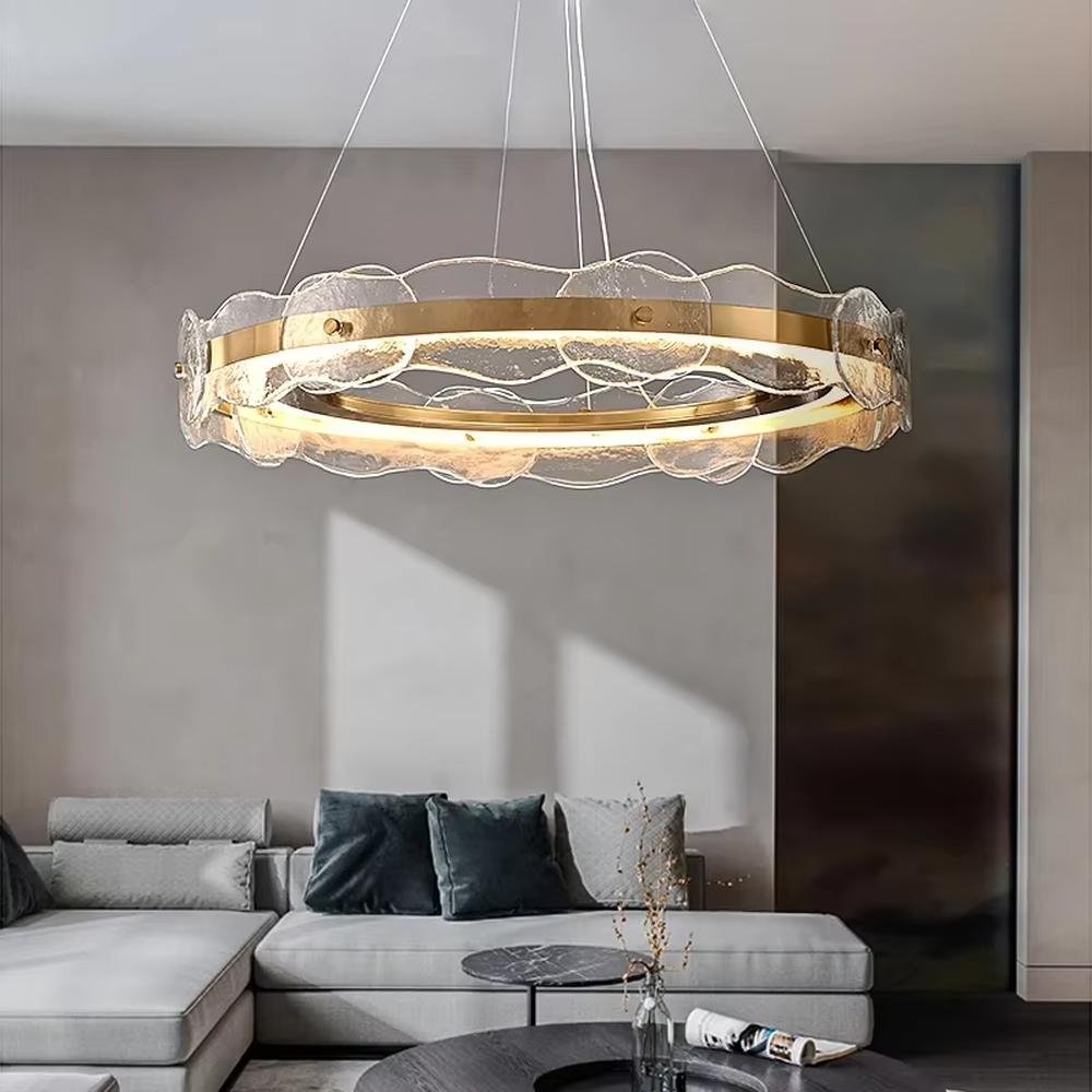A modern light luxury style double-layer ring chandelier, featuring a gold metal frame paired with transparent glass panels with water ripple texture. It emits a soft and brilliant glow when lit, combining decorative appeal with practical illumination, ideal for creating a high-end and elegant space atmosphere.