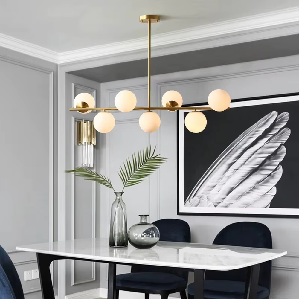 A modern light luxury style linear molecular ball chandelier, featuring a gold metal frame paired with asymmetrically arranged milky white glass glowing spheres. It emits a soft and uniform glow when lit, combining decorative appeal with practical illumination, ideal for creating a minimalist and sophisticated space atmosphere.
