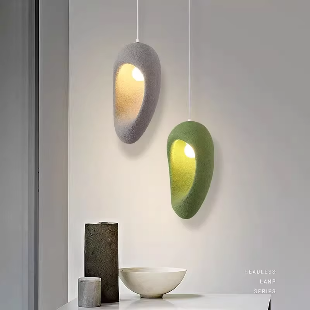 This is a modern wabi-sabi style pebble-shaped pendant lamp, made of frosted cement/resin material with a semi-embedded lighting design, available in colors like gray and green, which has both lighting and decorative functions, suitable for modern minimalist, wabi-sabi style bedrooms, entrances, cafes and other spaces.