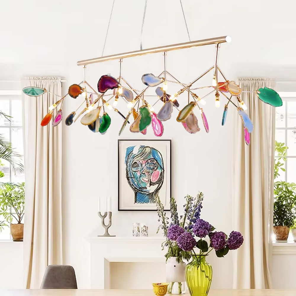 A modern art style linear chandelier, featuring a gold metal branch-like frame with suspended natural colorful agate slices. It emits soft and vibrant light when lit, combining artistic decoration with lighting functionality, ideal for creating a romantic and lively space atmosphere.
