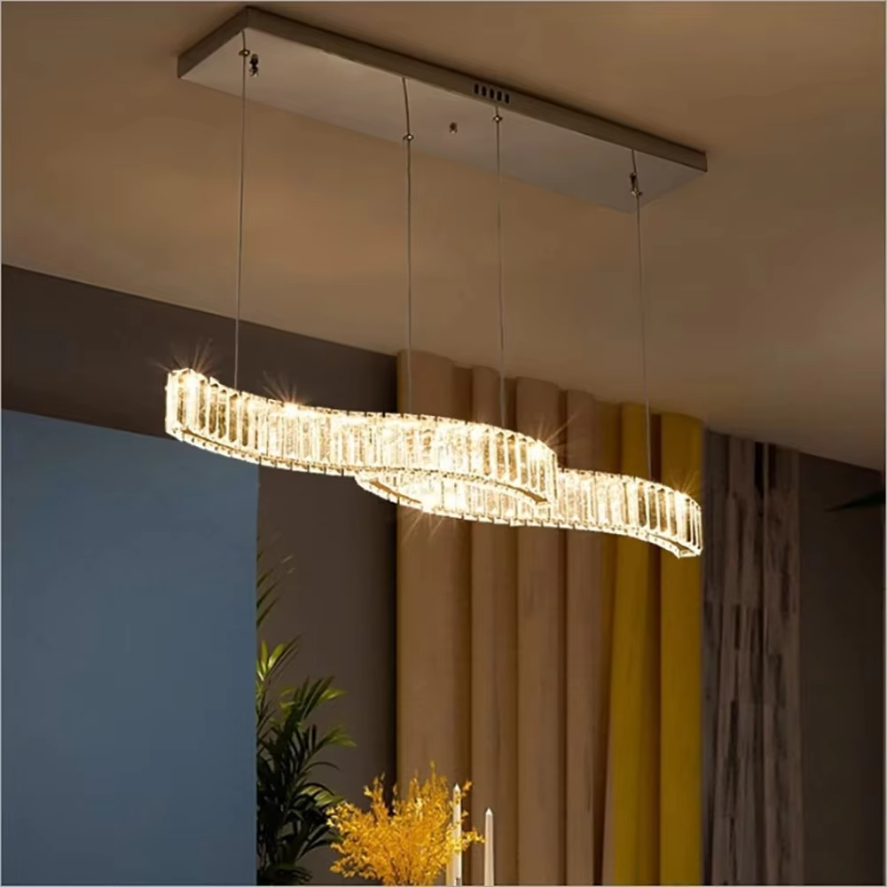 This modern light luxury linear chandelier features a gold metal ceiling plate, paired with faceted crystal strips to create an irregular undulating shape. Light refracts through the crystals to emit a brilliant glow, serving both lighting and decorative purposes, suitable for modern light luxury spaces such as dining rooms and bars.