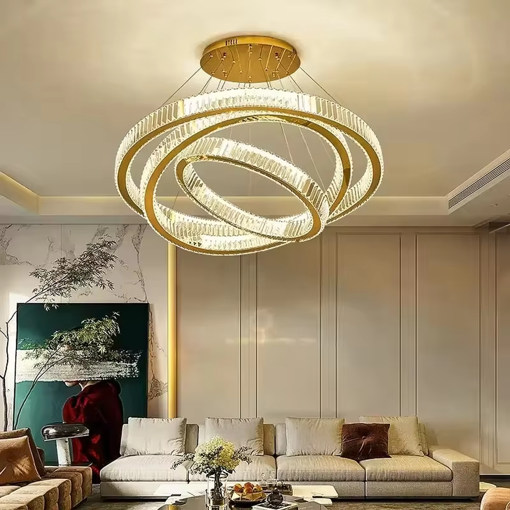 This chandelier features a core shape of multi-layer rings of varying sizes, with a lamp body made of high-transparency crystal material, paired with delicate metal suspension wires and a ceiling plate. The light presents a bright and soft gradient glow after passing through the crystal, combining modern design and luxurious texture. It is not only the core lighting tool for high-ceiling spaces, but also an artistic installation that enhances the space's style, suitable for a variety of modern light luxury style soft decoration scenarios.