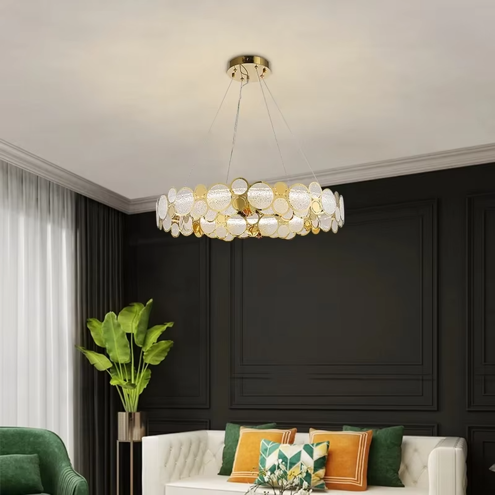 A modern light luxury style linear chandelier, featuring a gold metal frame with interlocked circular transparent glass panels and gold rings. It emits a brilliant yet soft glow when lit, combining decorative appeal with practical illumination, ideal for creating a sophisticated and high-end space atmosphere.