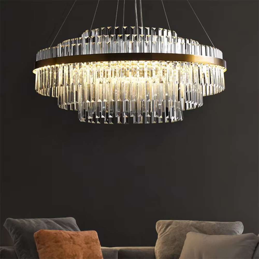 A modern light luxury style circular double-layer crystal chandelier, featuring a gold metal frame paired with multiple layers of long cut crystal strips. It emits a brilliant and soft glow when lit, combining decorative appeal with practical illumination, ideal for creating a luxurious and high-end space atmosphere.
