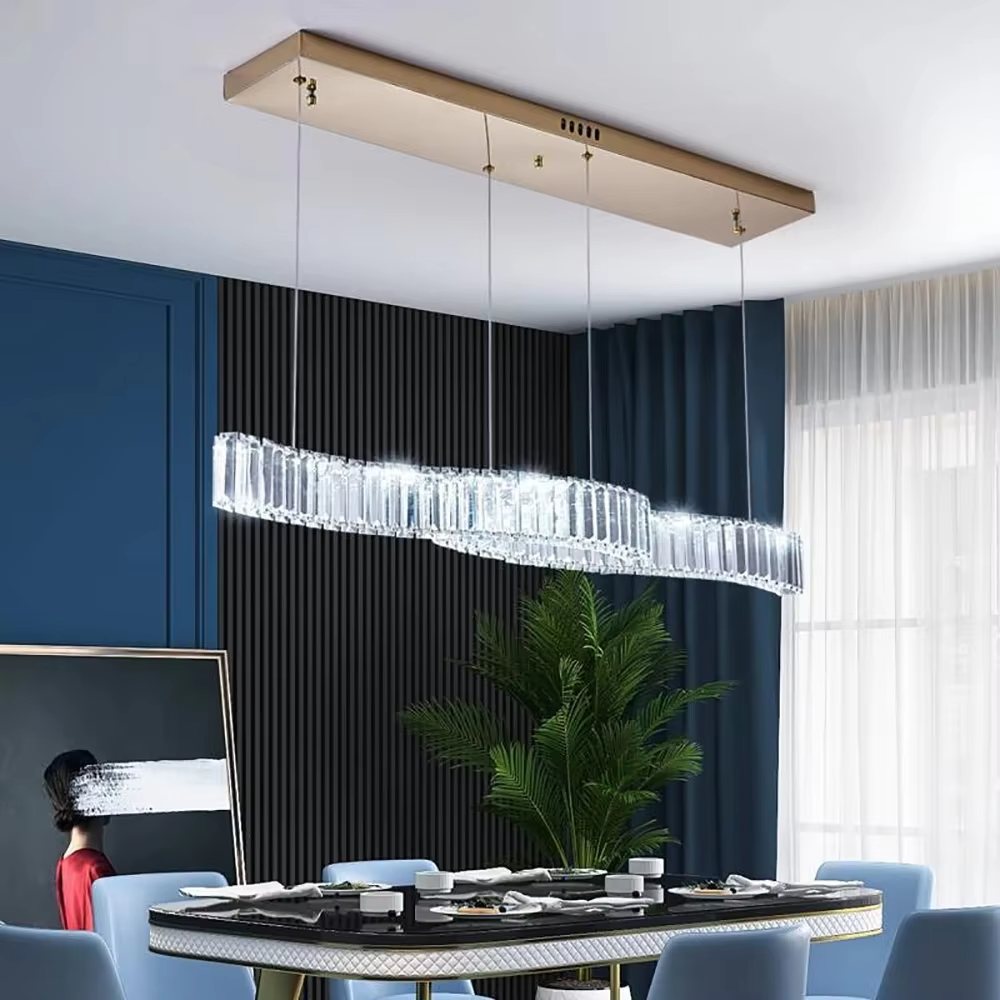 This modern light luxury linear chandelier features a gold metal ceiling plate, paired with faceted crystal strips to create an irregular undulating shape. Light refracts through the crystals to emit a brilliant glow, serving both lighting and decorative purposes, suitable for modern light luxury spaces such as dining rooms and bars.