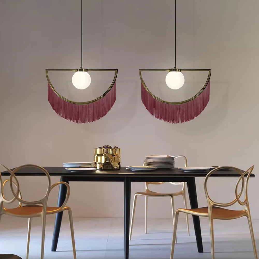 Modern minimalist semicircular tassel pendant lamp, with black-gold/pink-gold metal semicircular frames paired with semi-transparent lampshades, cascading same-color tassel decorations, built-in spherical light sources, emitting soft and warm light, combining decorativeness and lighting function, suitable for accent lighting and atmosphere creation in spaces such as bedroom nightstands, restaurant bars, and children's rooms.