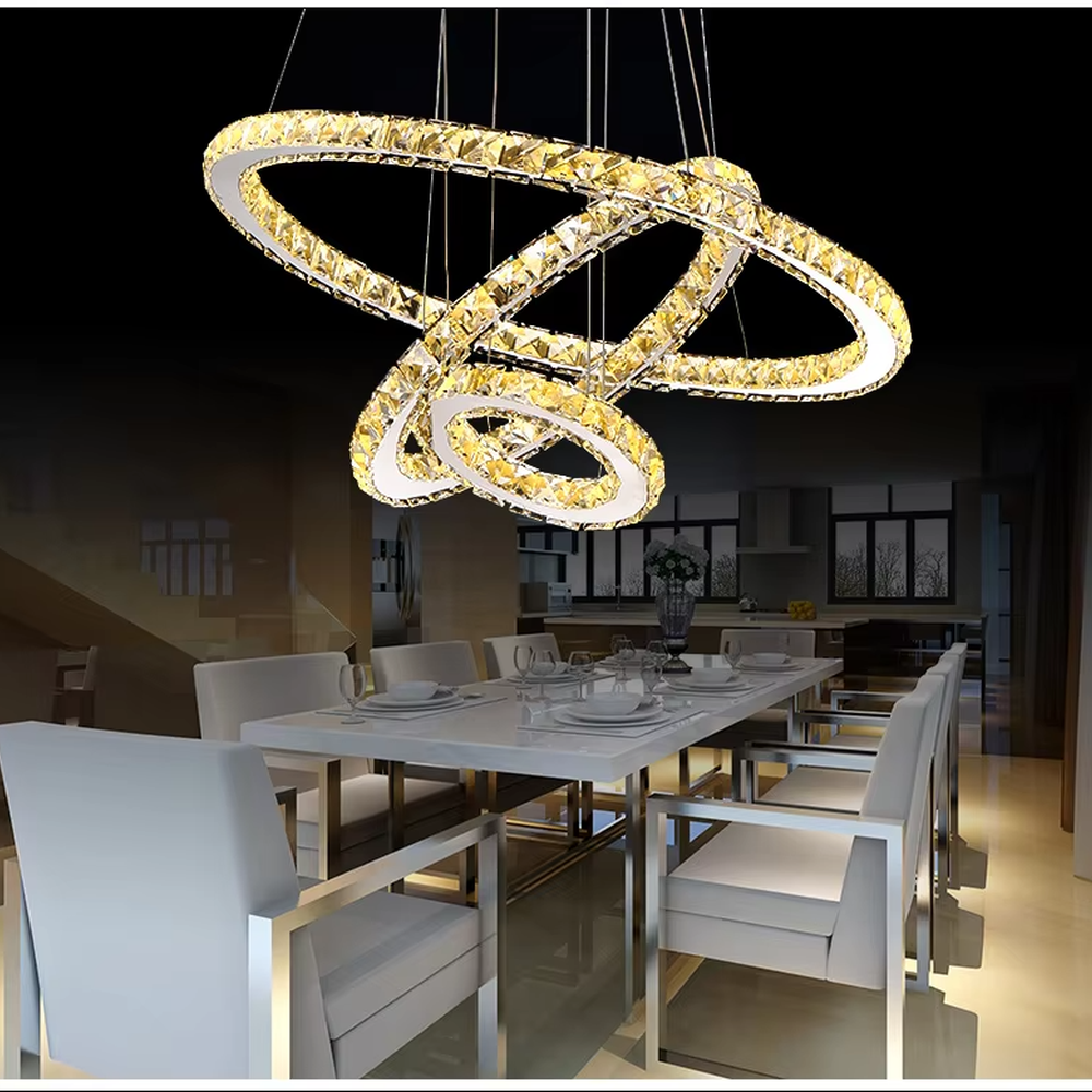 This light luxury black-gold interlaced ring crystal chandelier features a multi-layer flowing ring shape made of metal frames and crystal strips, with light refracting a brilliant halo through the crystals, serving both lighting and decorative purposes, suitable for modern light luxury spaces such as living rooms and dining rooms.