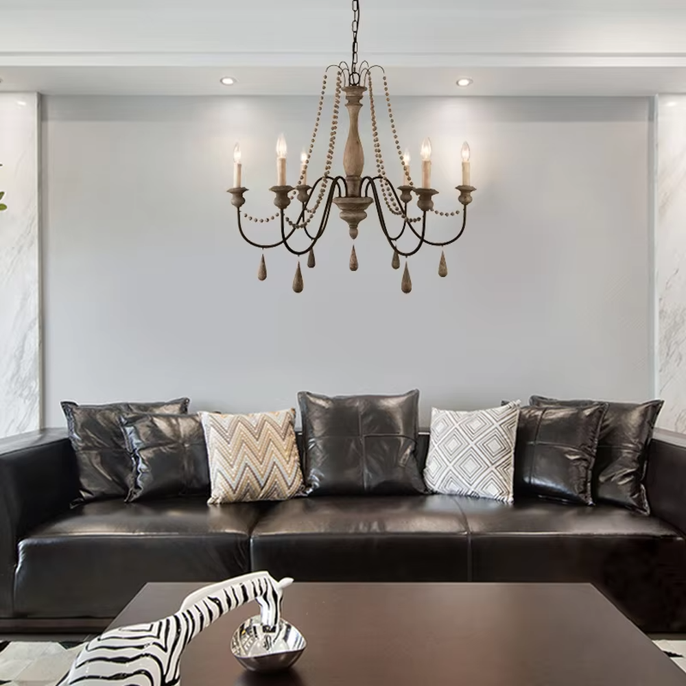 A French country retro style 6-head chandelier, featuring a weathered solid wood main frame paired with iron lamp arms, wooden bead chains and teardrop pendants, using candle-shaped bulbs. It emits a warm and soft glow when lit, combining decorative appeal with practical illumination, ideal for creating a cozy and retro space atmosphere.