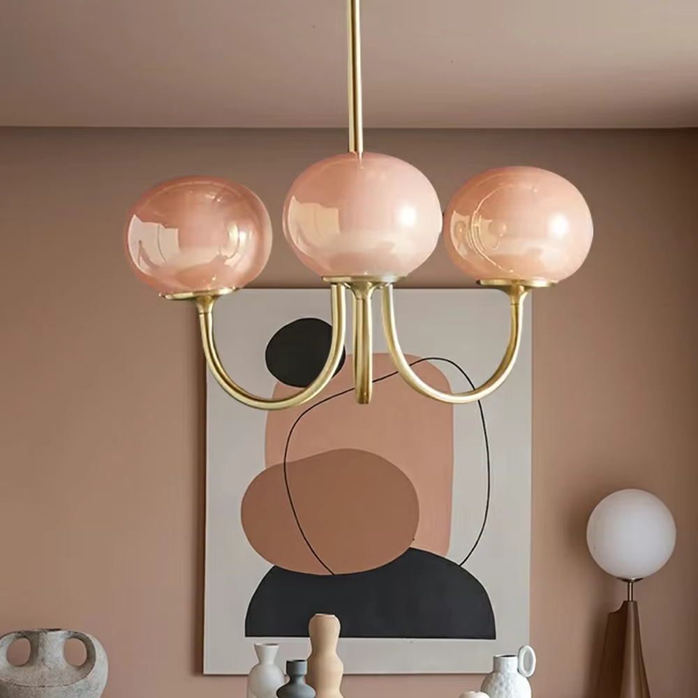 This light luxury pink-gold spherical chandelier features a curved bracket made of gold metal, paired with three pink gradient spherical lampshades, with soft and romantic light, serving both lighting and decorative purposes, suitable for warm spaces such as dining rooms and bedrooms.
