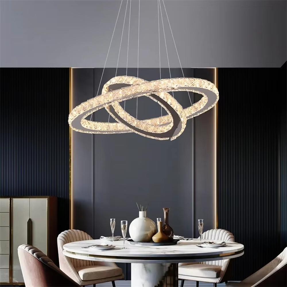 This is a modern light luxury style three-layer ring crystal chandelier, with a silver metal ceiling plate paired with glittering and transparent crystal rings, which has both lighting and decorative functions, suitable for living rooms, dining rooms, villa high-ceiling spaces, etc.