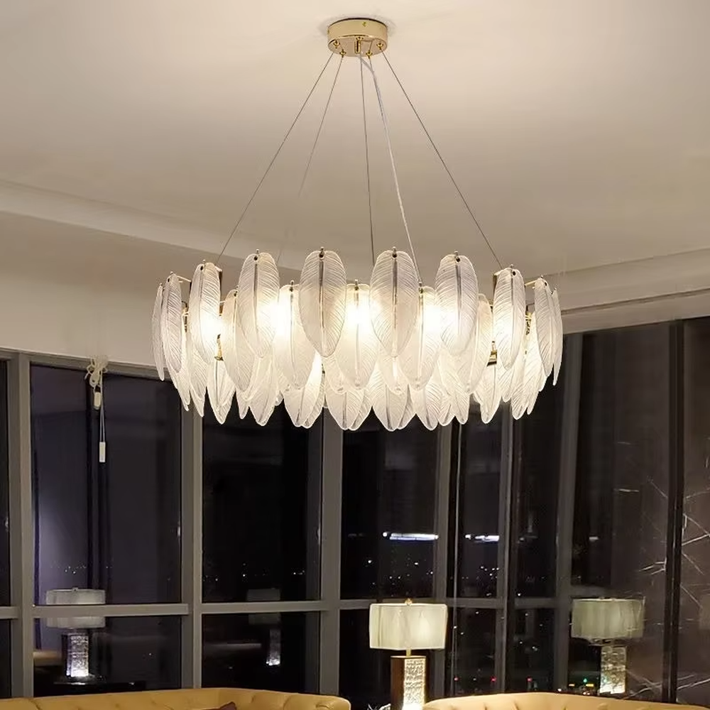 A modern light luxury style ring chandelier, featuring a gold metal frame paired with double-layer feather-shaped gradient glass panels. It emits a soft and warm glow when lit, combining decorative appeal with practical illumination, ideal for creating a romantic and elegant space atmosphere.
