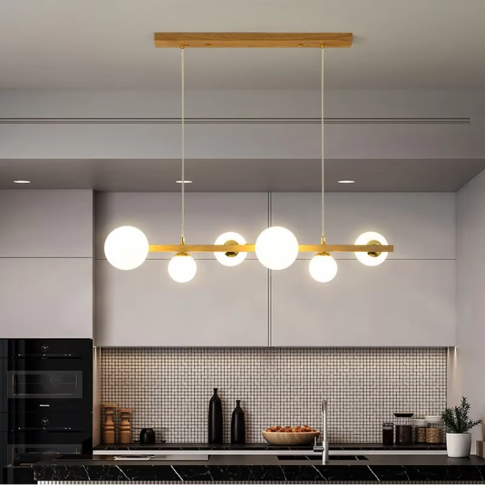 Nordic-style gold linear chandelier with a wood-like finish, paired with multiple round milk-white glass ball lampshades. It features a simple and lightweight design, emitting soft and gentle light, serving as a modern home lighting fixture that combines illumination and decoration.

