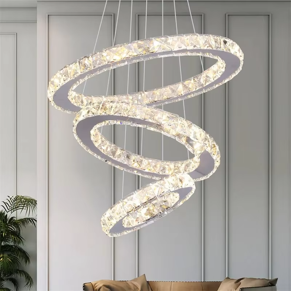 This is a modern light luxury style three-layer ring crystal chandelier, with a silver metal ceiling plate paired with glittering and transparent crystal rings, which has both lighting and decorative functions, suitable for living rooms, dining rooms, villa high-ceiling spaces, etc.