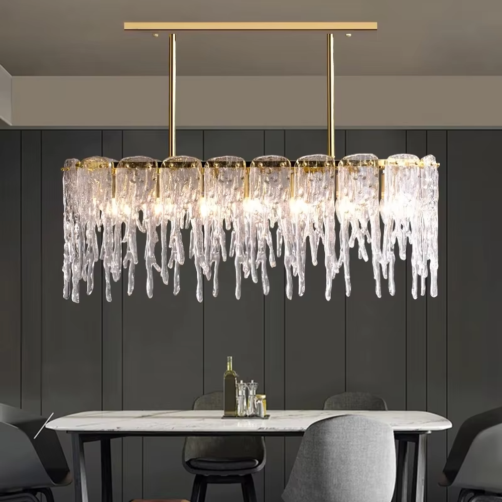 This modern light luxury linear chandelier features a gold metal frame paired with icicle-shaped transparent crystal pendants. Light refracts through the crystals to emit a brilliant and soft glow, serving both lighting and decorative purposes, suitable for modern light luxury spaces such as dining rooms and villa living rooms.