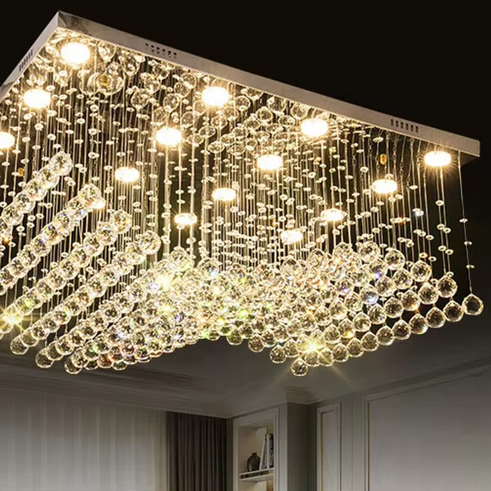 This modern light luxury rectangular crystal ceiling lamp is composed of a large number of hanging crystal bead strings, presenting a layered waterfall shape. The light refracts through the crystal to emit a brilliant and transparent glow, serving both core lighting and decorative purposes, suitable for modern light luxury style spaces such as living rooms and dining rooms.
