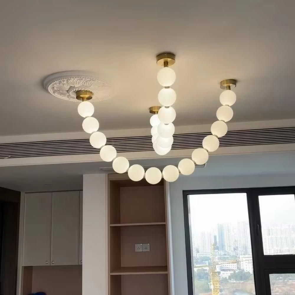 Modern Light Luxury Curved Beaded Chandelier, Milk White Spherical Lampshades Connected in a Wave Shape, Gold Metal Base, Serves Both Lighting and Decorative Purposes, Ideal for Living Rooms, Dining Rooms, Open Kitchens, etc.