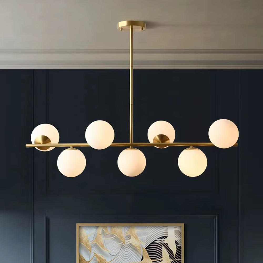 A modern light luxury style linear molecular ball chandelier, featuring a gold metal frame paired with asymmetrically arranged milky white glass glowing spheres. It emits a soft and uniform glow when lit, combining decorative appeal with practical illumination, ideal for creating a minimalist and sophisticated space atmosphere.