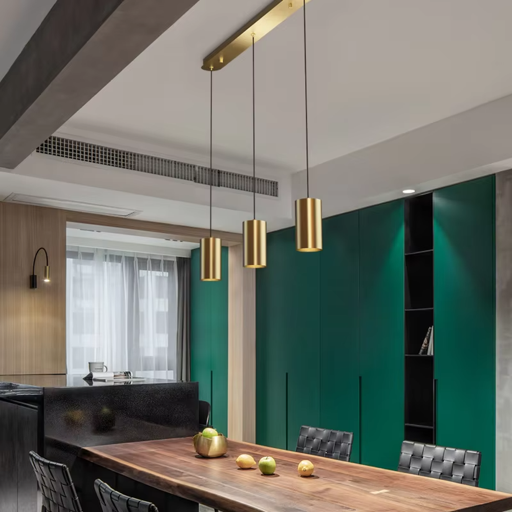 This is a modern light luxury gold cylindrical triple-head pendant light, featuring a linear bronze metal base paired with cylindrical lamp bodies, with a staggered hanging design that is simple and neat. It emits soft and uniform light, serving both lighting and decorative purposes, suitable for dining rooms, bars, minimalist living rooms and other scenarios.