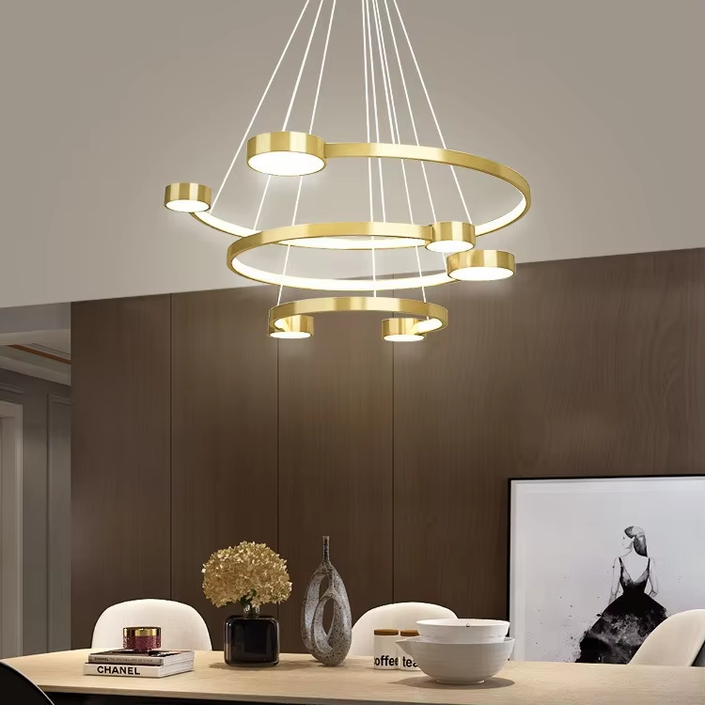 A modern light luxury multi-layer ring floating chandelier, featuring a golden metal ring structure paired with LED light strips and a bottom circular luminous panel. It has an adjustable suspension rod design, combining lighting and decorative functions, ideal for creating an elegant and high-end space atmosphere.