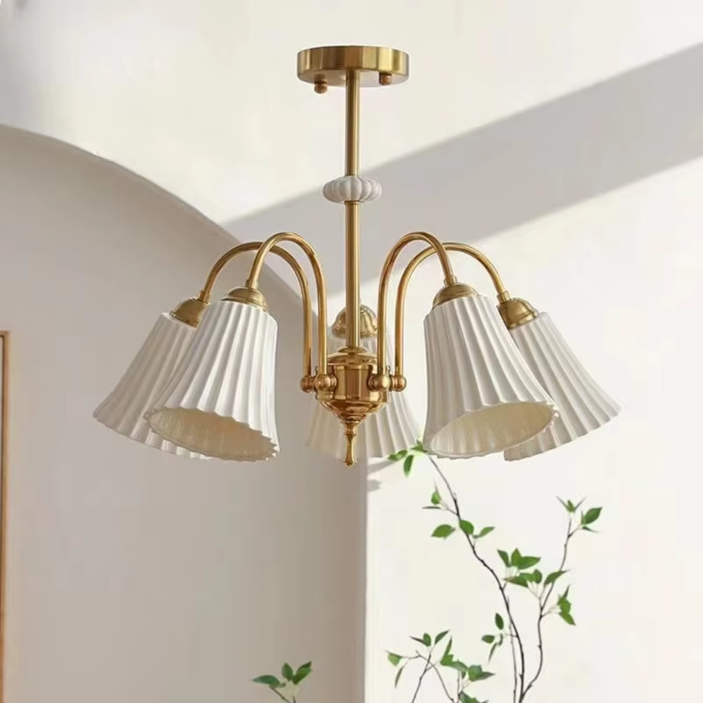 A French retro light luxury style 3-head chandelier, featuring a brass-colored metal frame paired with pleated fabric lampshades. It emits a soft and warm glow when lit, combining decorative appeal with practical illumination, ideal for creating an elegant and romantic space atmosphere.
