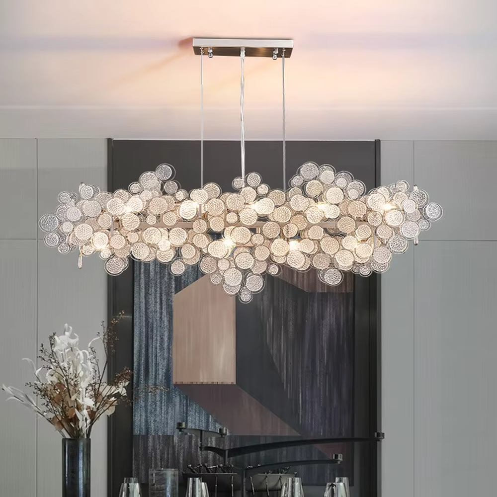 This light luxury silver diamond cloud chandelier is composed of a large number of layered silver metal discs with diamond-like texture, presenting a fluffy and light cloud shape. Light refracts through the discs to emit a brilliant and soft halo, serving both lighting and decorative purposes, suitable for modern light luxury spaces such as living rooms and dining rooms.