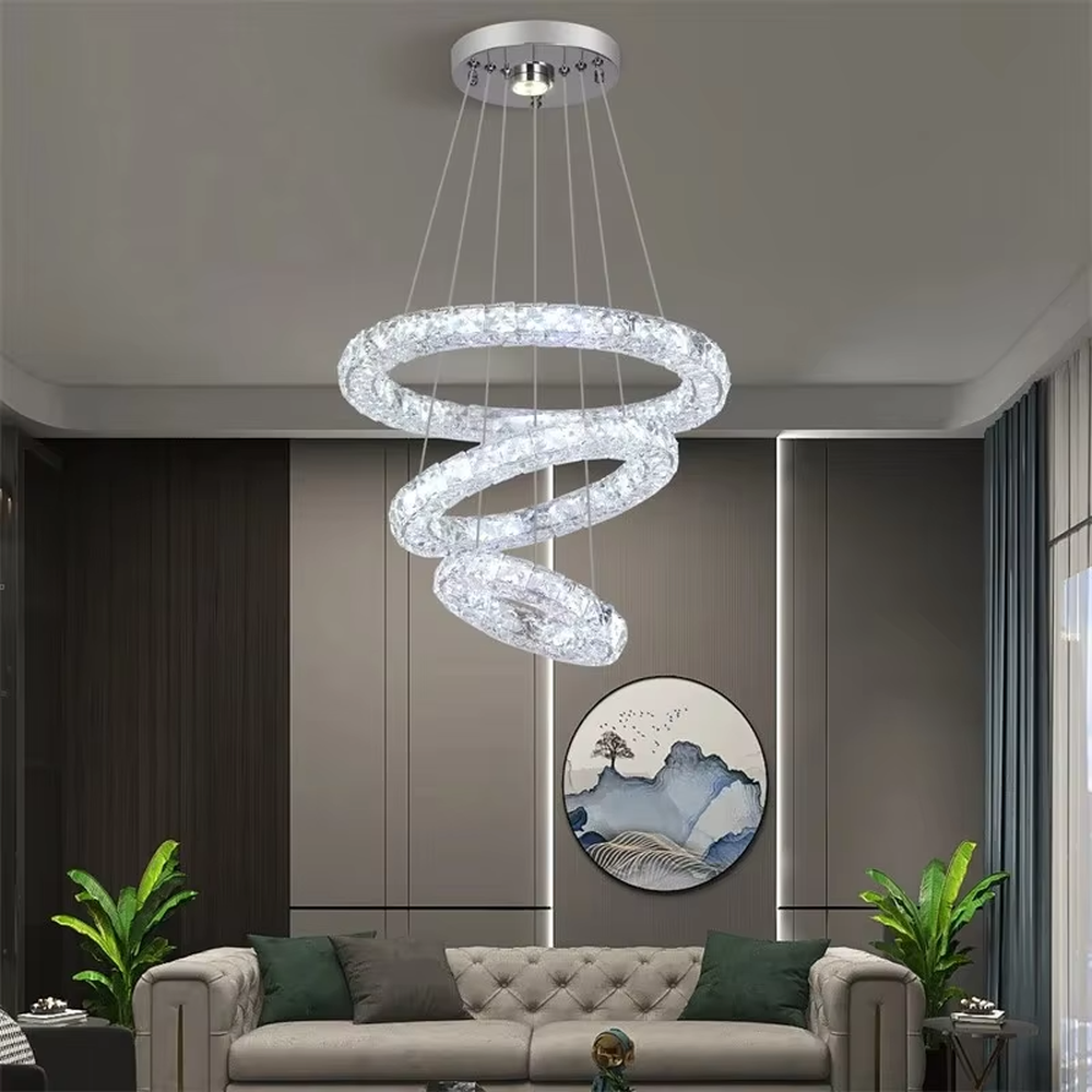 This is a modern light luxury style three-layer ring crystal chandelier, with a silver metal ceiling plate paired with glittering and transparent crystal rings, which has both lighting and decorative functions, suitable for living rooms, dining rooms, villa high-ceiling spaces, etc.