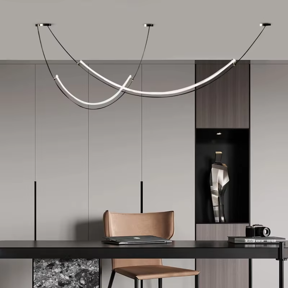 A modern minimalist style double-arc linear chandelier, featuring a black metal frame with built-in white LED light strips, shaped like flowing light arcs suspended in space. It emits a soft and uniform glow when lit, combining decorative appeal with practical illumination, ideal for creating a minimalist and sophisticated space atmosphere.