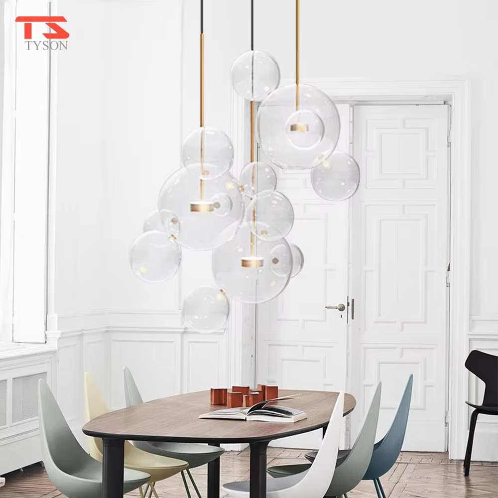 A modern light luxury style bubble-shaped chandelier, suspended by gold wires, paired with transparent glass bubble lampshades of varying sizes. It emits a soft and transparent glow when lit, combining decorative appeal with practical illumination, ideal for creating a dreamy and light space atmosphere.