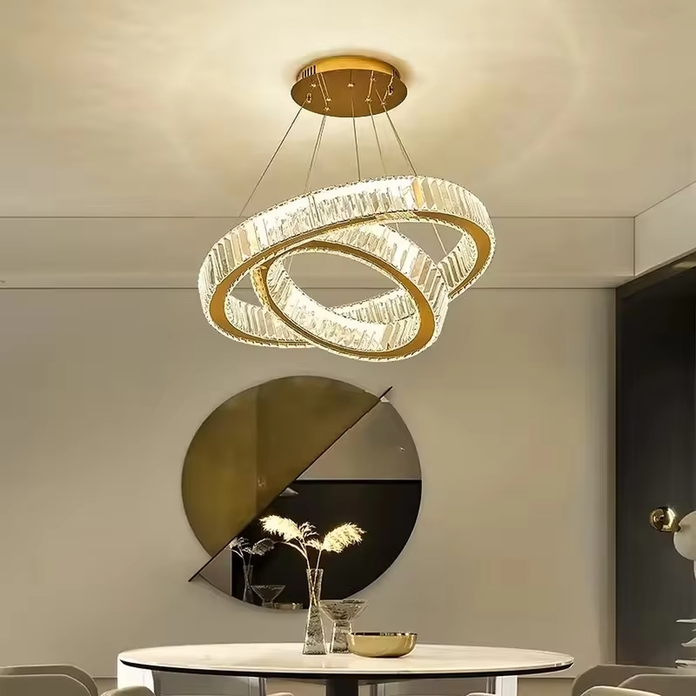 This modern light luxury multi-layer interlaced ring crystal chandelier features a gold metal frame paired with a high-transparency crystal lamp body. The multi-layer rings are staggered and interwoven to present a dynamic interstellar shape. The light refracts through the crystal to emit a brilliant and soft glow, serving both lighting and decorative purposes, suitable for modern light luxury style spaces such as living rooms and dining rooms.