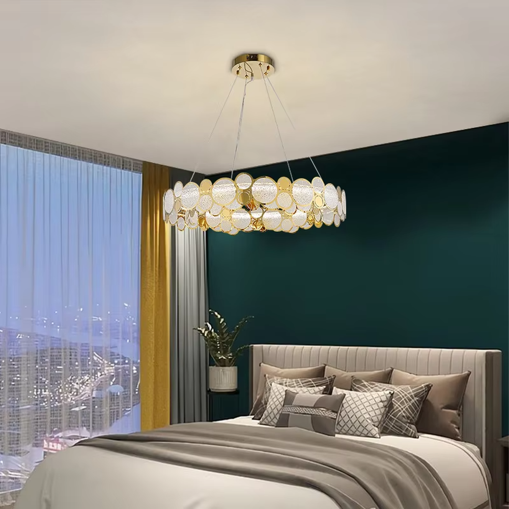 A modern light luxury style linear chandelier, featuring a gold metal frame with interlocked circular transparent glass panels and gold rings. It emits a brilliant yet soft glow when lit, combining decorative appeal with practical illumination, ideal for creating a sophisticated and high-end space atmosphere.